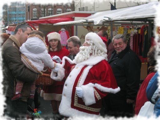 Handje schudden met de aller kleinste. een vriendelijke kerstman op de markt.